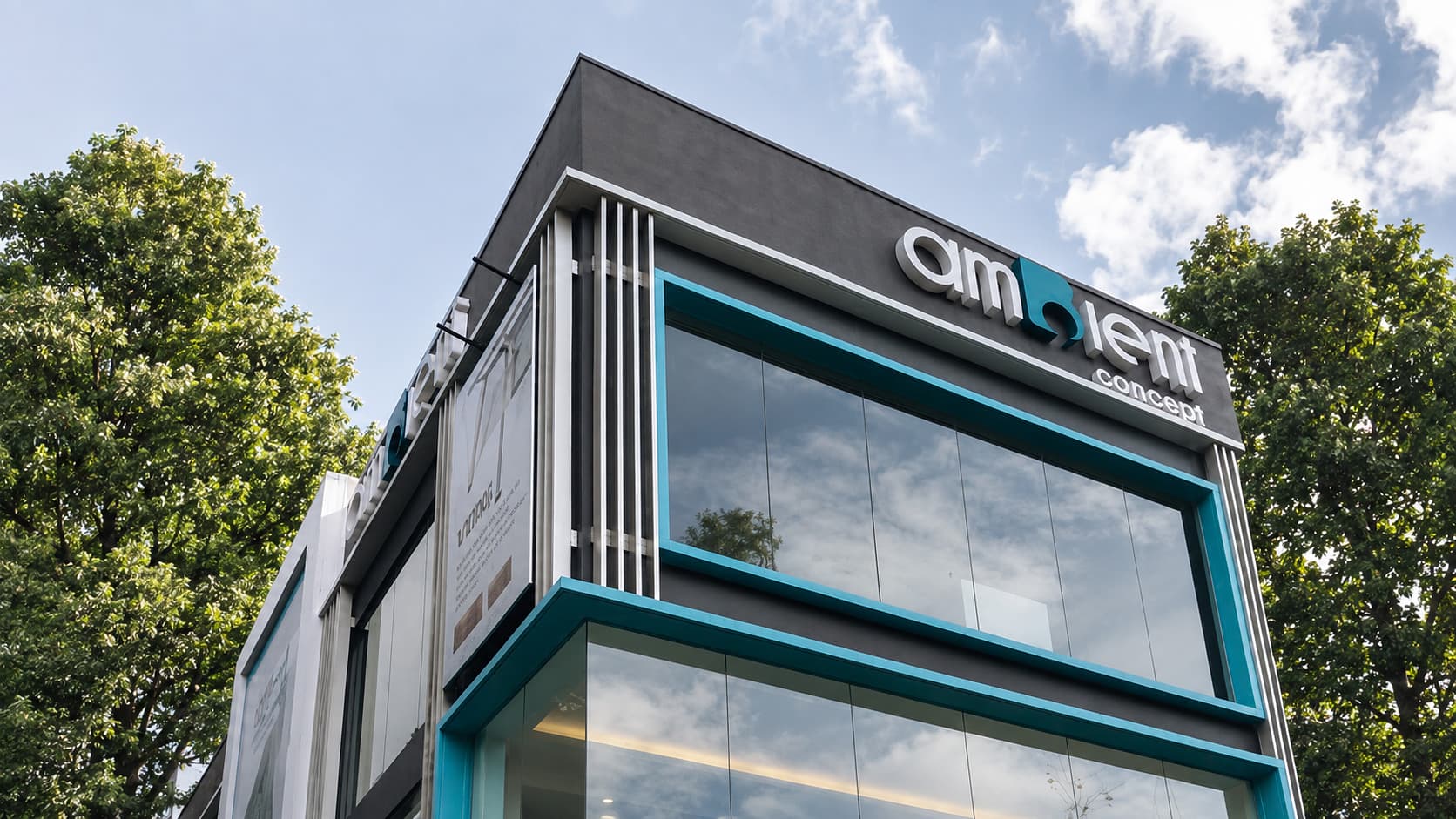 The Ambient Concept office, a corner building in charcoal and teal with box-up signage on the parapet